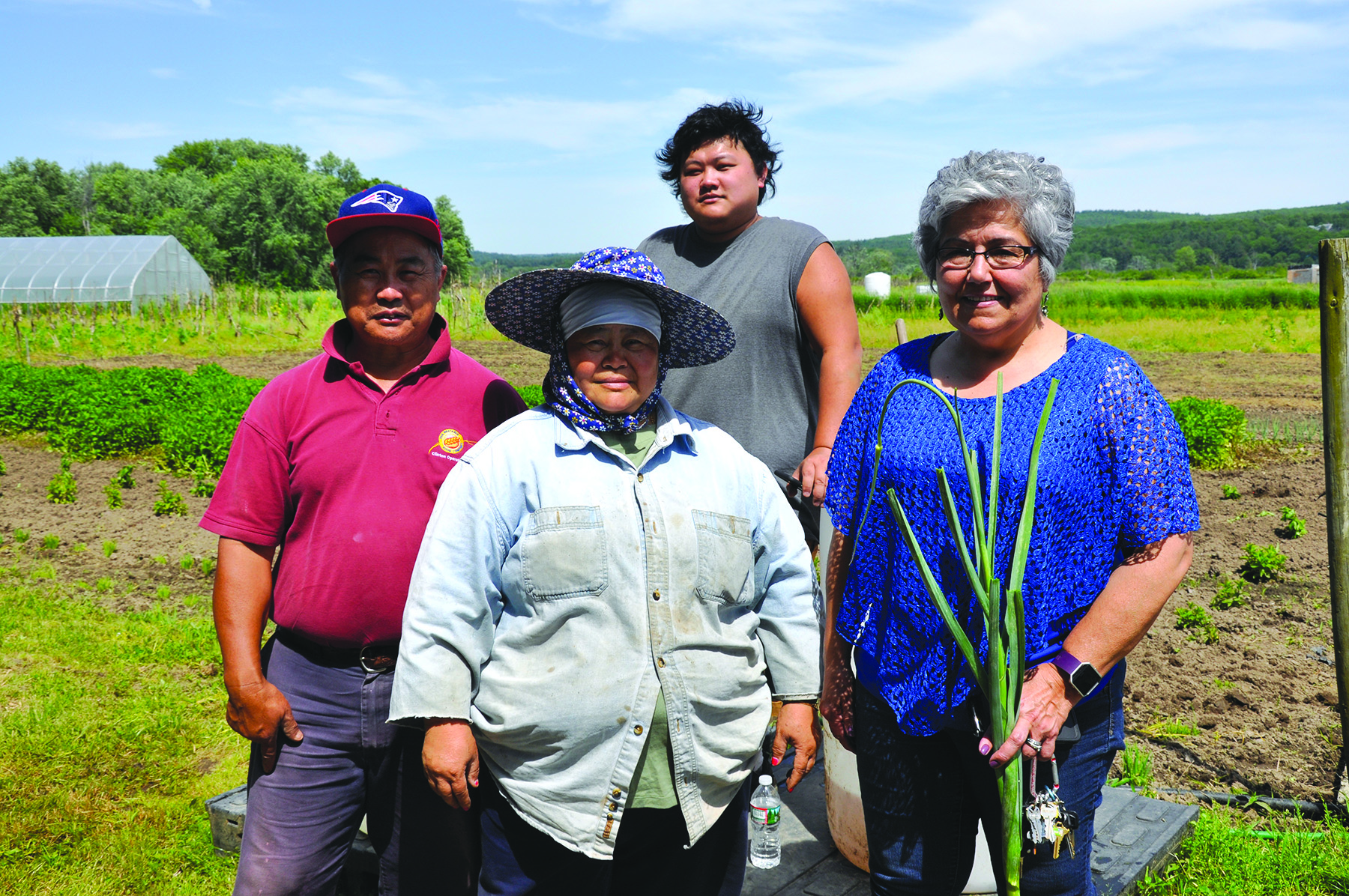 Maria Moreira, co-founder and executive director of World Farmers organization (far right) advocates for refugee and immigrant farmers to have fair access to markets. She is joined by Ger Hang (far left), his wife, Yia Ly, and their youngest, Suny, at Flats Mentor Farm. (Photo/Deborah Burke Henderson)