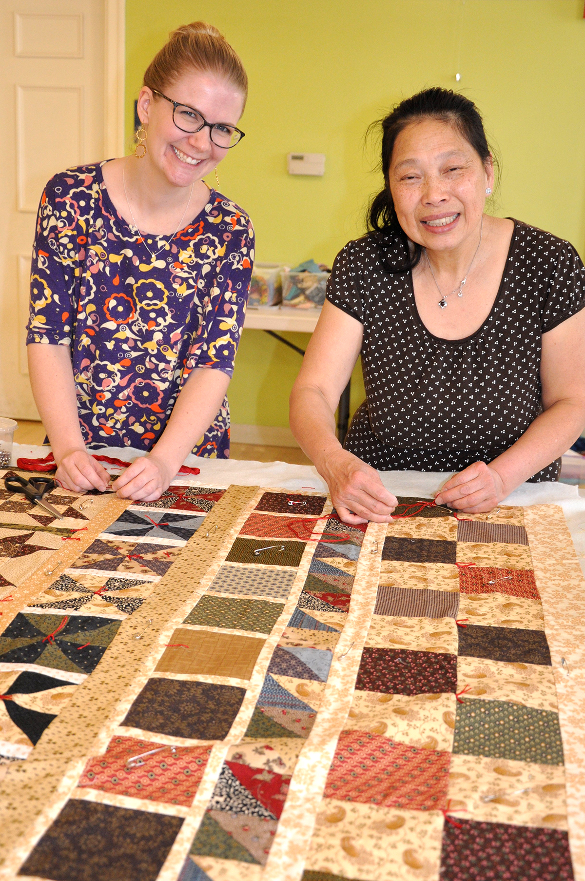 Ashland residents Heidi Wesolowski and Irene Richards learn to hand-tie a comfort quilt at The Power of the Quilt Project spring quilt-a-thon. (Photo/Deborah Burke Henderson)