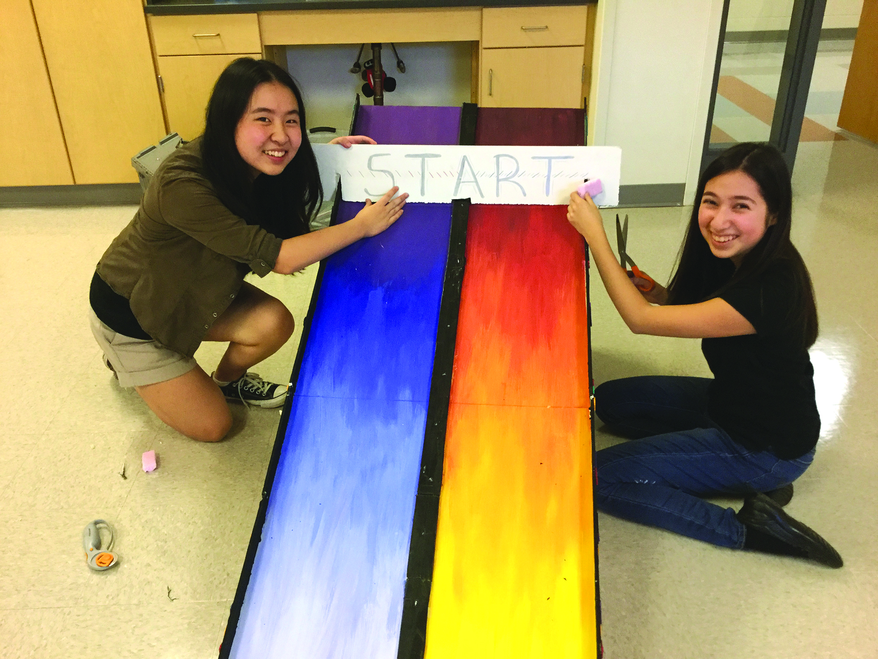 The Ashland Robotics Club will host its annual Robot Rodeo on November 18th. Students will share their experience and enthusiasm with younger kids. Shown here, Ashland Robotics Club members Jewel Han and Daphne García remodel the popular bobsled station.