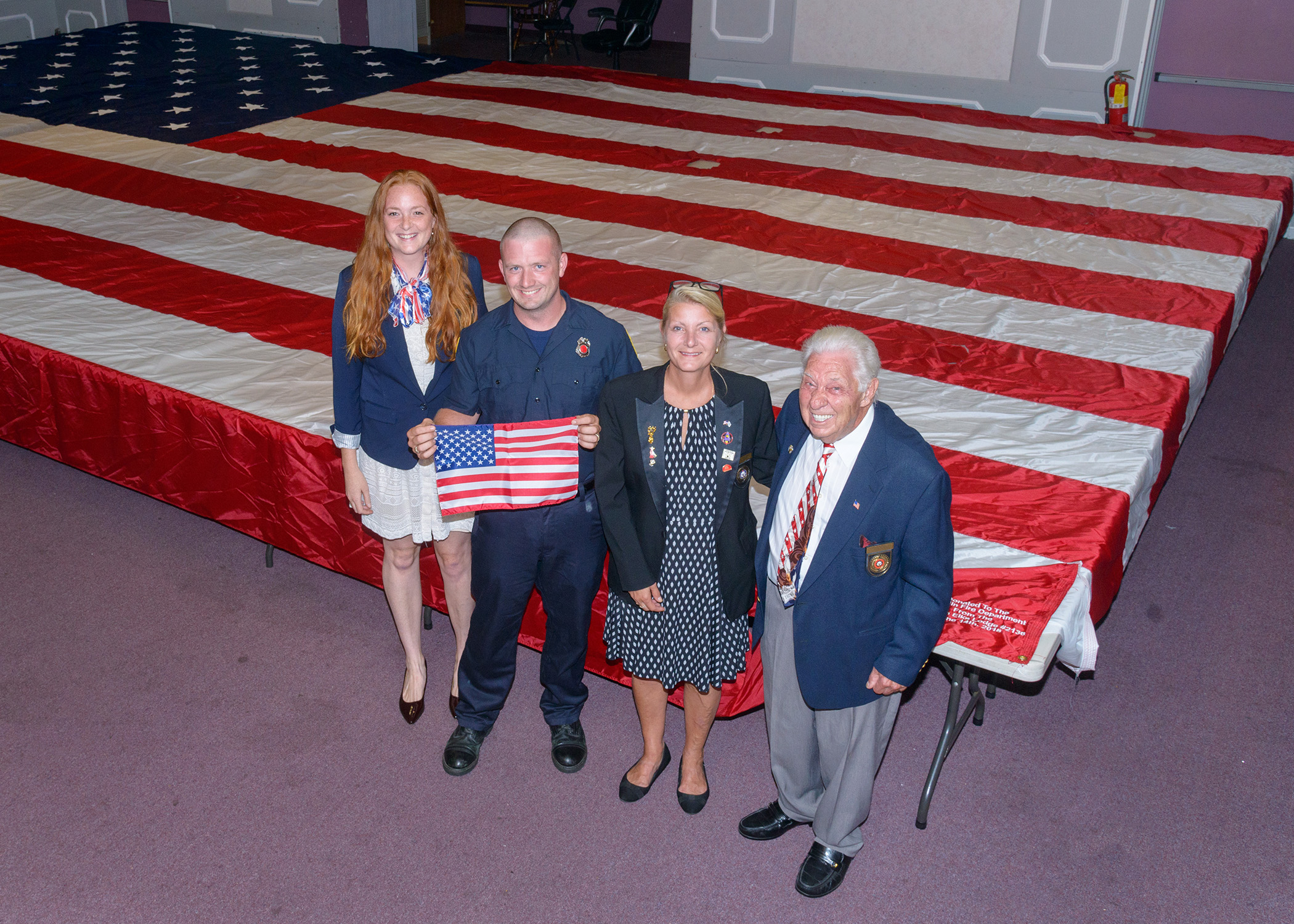 Franklin Fire Department’s new colors will wave in red, white and blue majesty thanks to the donation of this 1,000 square-foot flag from the Franklin Elks Lodge No. 2136, made possible by a grant from the Elks National Foundation. From left to right, Franklin Elks Exalted Ruler, Katie Morvan, Franklin Firefighter, Chris Schmall, Secretary, Michele Walker, Chaplain, Frank Liotta, PDD