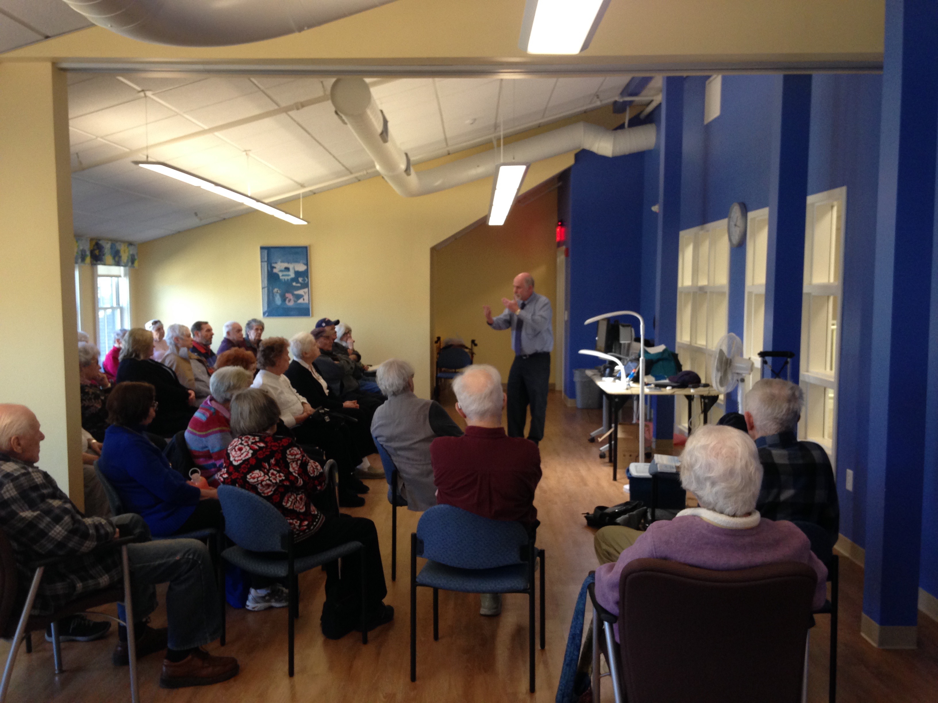 The Assistive Technology Center, or “Low Vision Center,” at the Franklin Senior Center is one of three centers in Massachusetts established by the Mass. Executive Office of Elder Affairs and Massachusetts Councils on Aging. It demonstrates assistive technology to those experiencing vision loss, and offers a drop-in program on the second Tuesday of each month. Here, Stu Flom from Adapti-Vision demonstrates an optical reader called an OCR to a group of about 35 attendees.