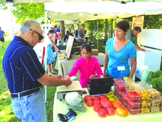 Laura and her daughter Li attend to customer Ed Gentili at the Ashland Farmers Market. (Photo/supplied)