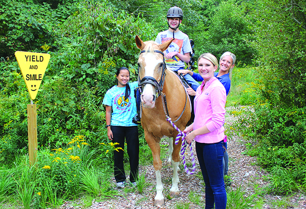 Riders work together with volunteers and instructors during their lessons, and enjoy experiences outside as well as inside the riding ring. (Photo/Jenna Kaplan)