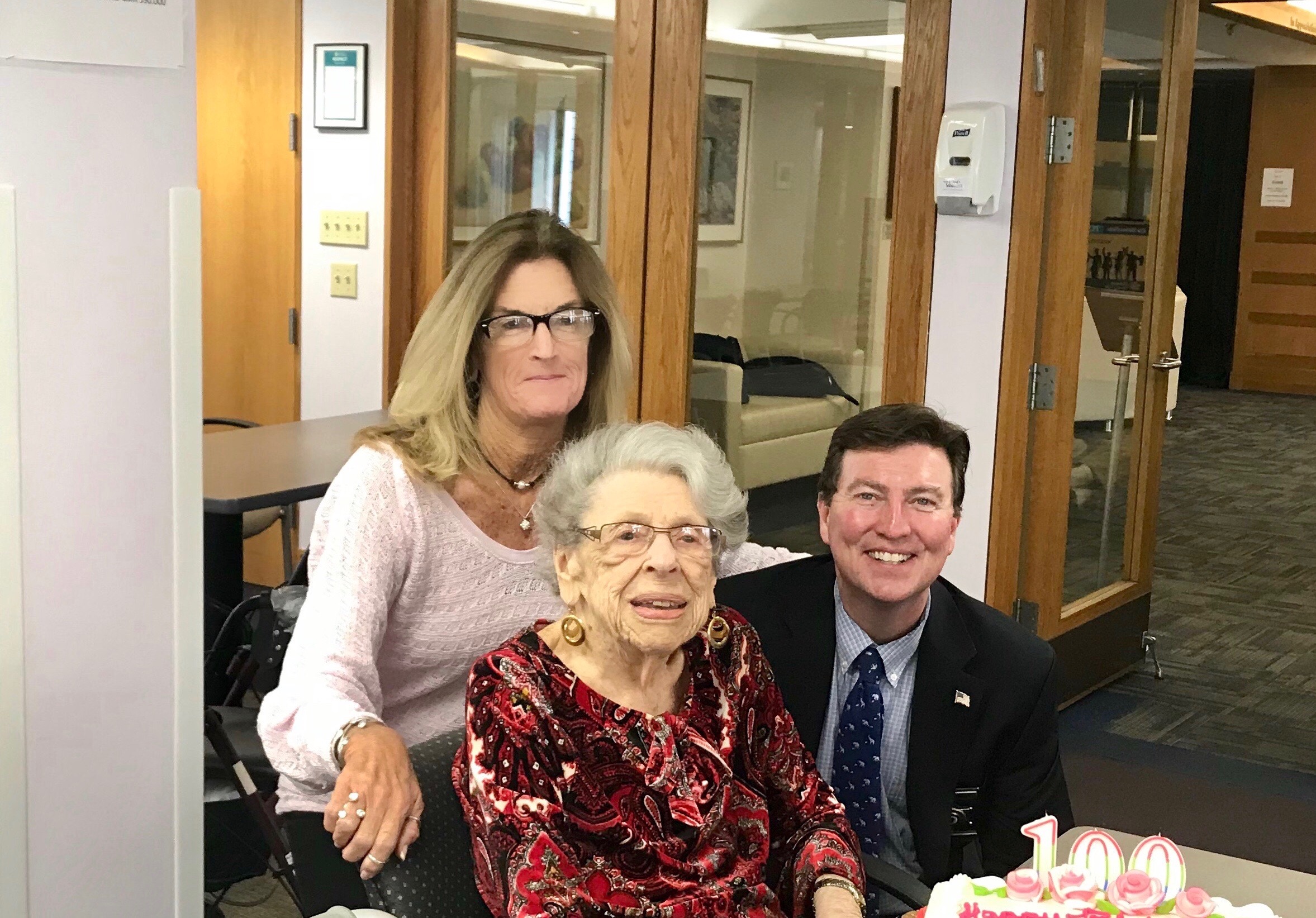 101-year-old Rose Less, of Randolph, has been enrolled in “Are You Ok?”, a program of the  Norfolk County Sheriff’s Office, for many years. This free daily phone call checks on seniors and disabled citizens living alone in Norfolk County. From left, Cheryl Bambery, Deputy Sheriff/TRIAD Officer, Rose Less, and Norfolk County Sheriff Jerome McDermott.