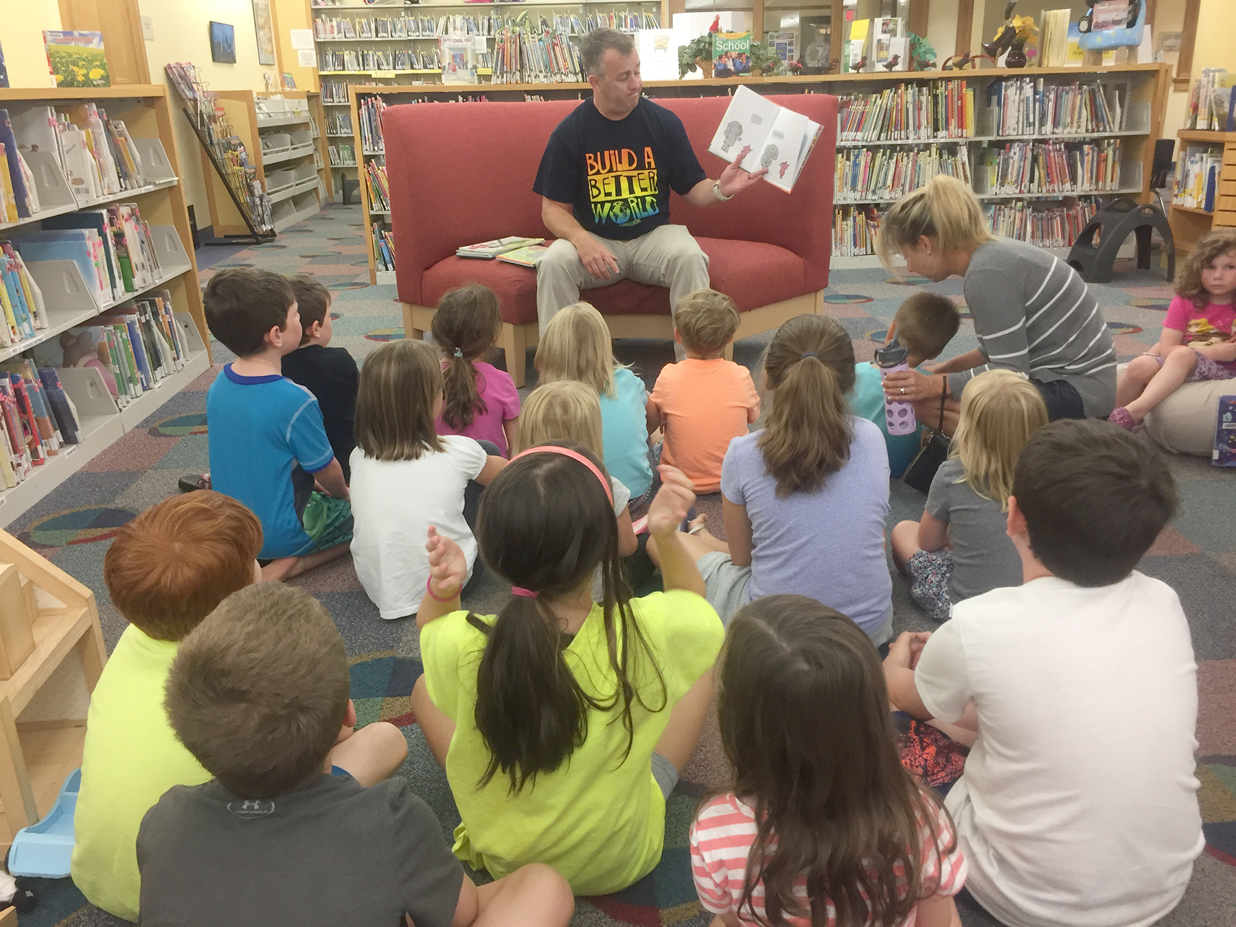 Mr. Peter Regan, principal at the Warren School, reads aloud to a group of kids at the library last summer. (Photo/supplied)