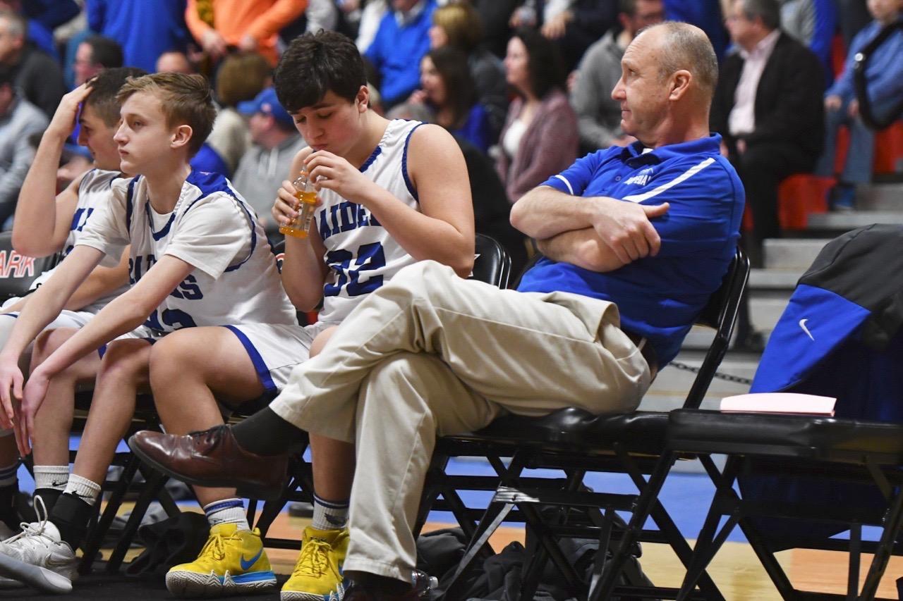 Volunteer coach Tom Hammann prefers to sit at the end of the Hopedale bench for every game. photo by Steve Bassignani