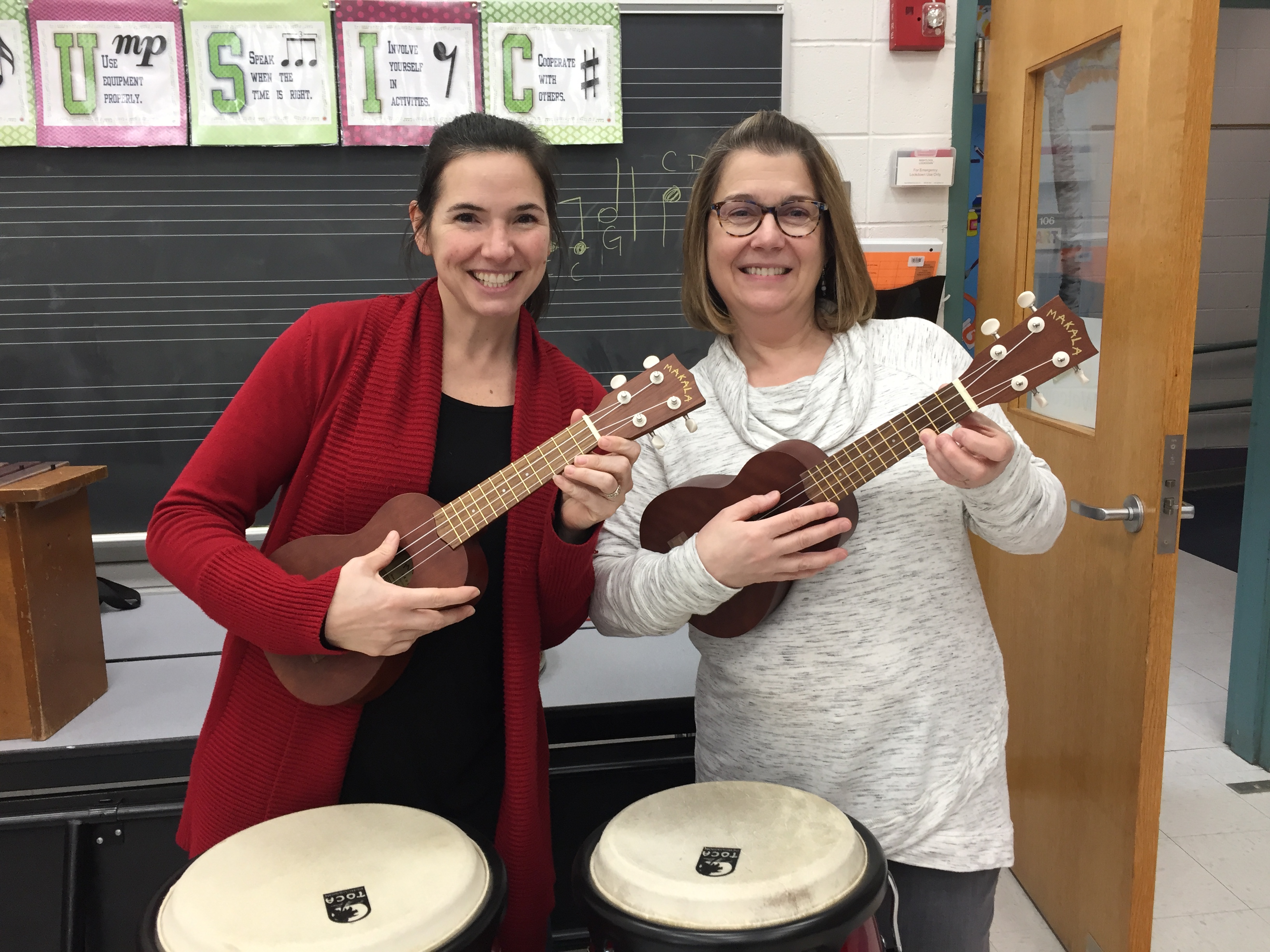 Shown are Holliston elementary school music teachers, Chrissy Petersen and Lori Anderson York, who will be teaching ukulele to the Holliston 5th graders through the Brian Ahronian Ukulele Project. Donations in Ahronian’s memory to the Holliston Music and Arts Parent Association purchased 28 ukuleles for students in order to ignite a lifelong love of music making.  Photo credit: Michelle Tate